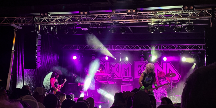 concert with guys singing on stage under purple lights