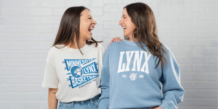 two girls looking at each other laughing in Minnesota Lynx apparel