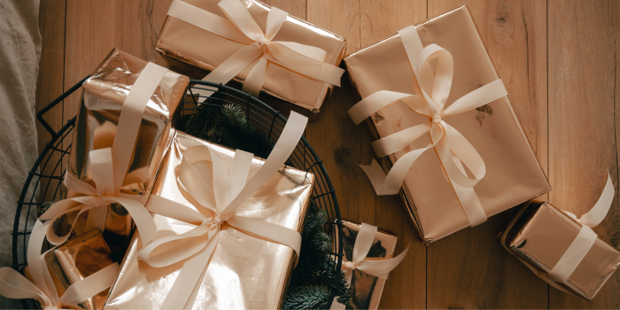 close up picture of gifts wrapped and with bows on the floor