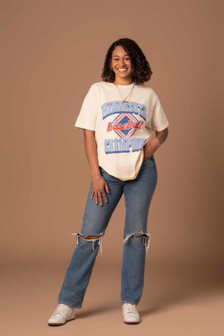 picture of a girl wearing cream colored cotton t-shirt with a red white and blue vintage inspired minnesota baseball screenprinted design