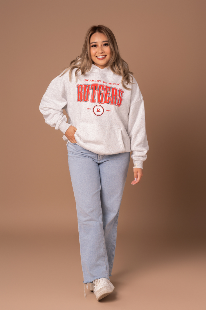 picture of a girl in a ash gray hoodie with a vintage inspired red, black, and white Rutgers University screenprinted design