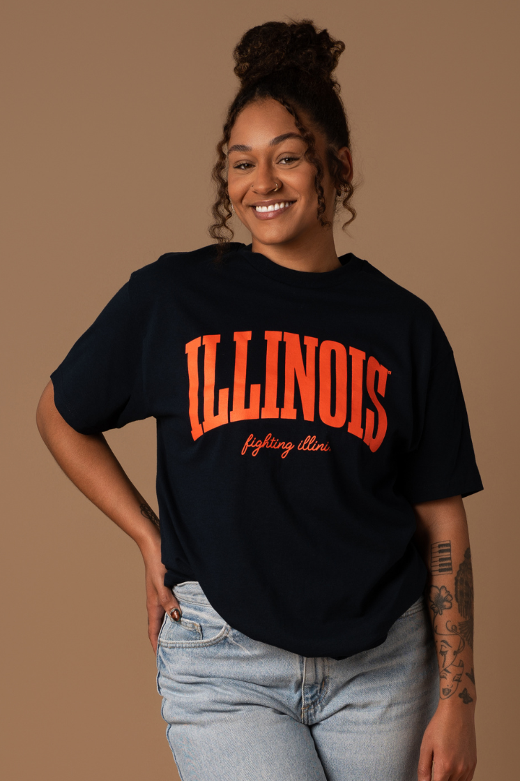 Close up of model wearing a navy blue comfortable and understated University of Illinois women's t-shirt that has team colors orange "Illinois Fighting Illini" screenprinted decoration.