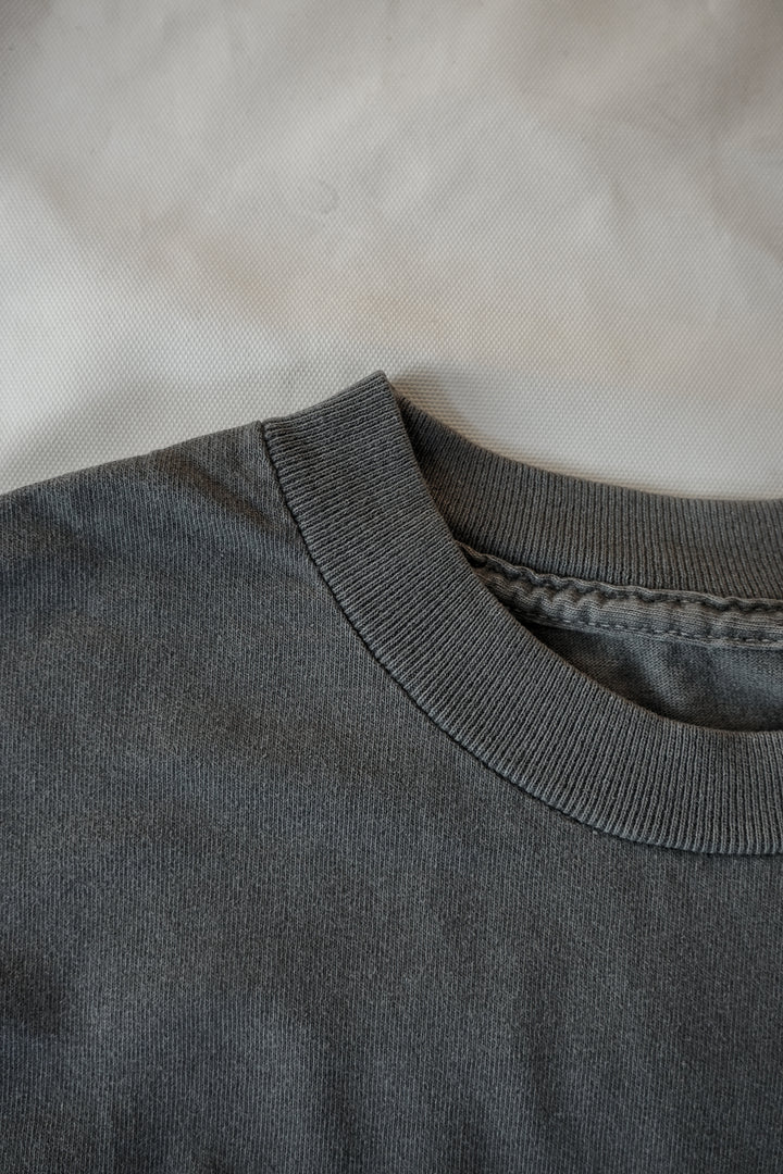 a close up of a faded black cotton tee's collar