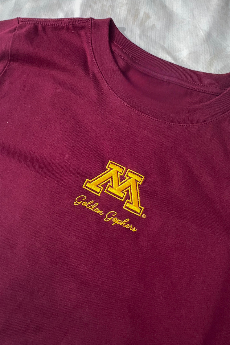 A maroon t-shirt with a small, yellow Minnesota logo and Golden Gopher text