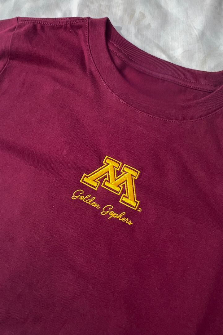 A maroon t-shirt with a small, yellow Minnesota logo and Golden Gopher text