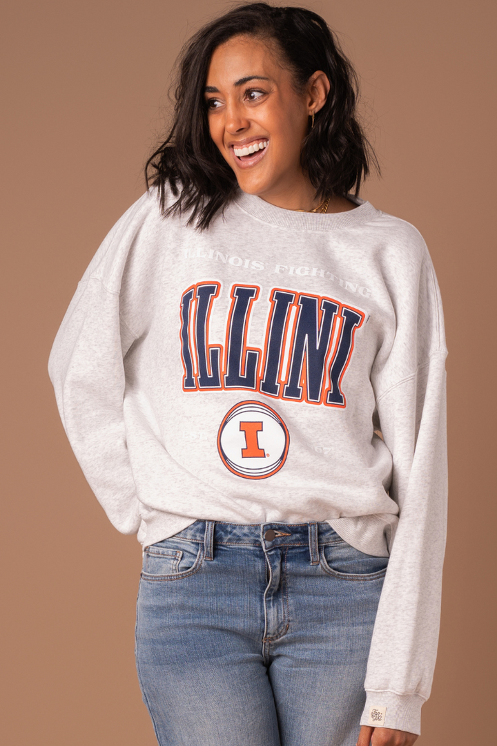 University of Illinois Fighting Illini Crew Neck Sweatshirt close up. The sweater has orange, navy blue, and white screen printed detail with licensed Illinois trademarks.