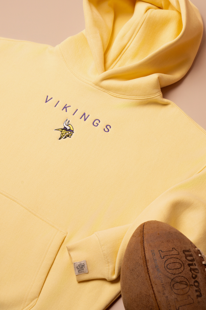 A yellow hoodie with purple 'Vikings' text and a small Vikings logo in the center