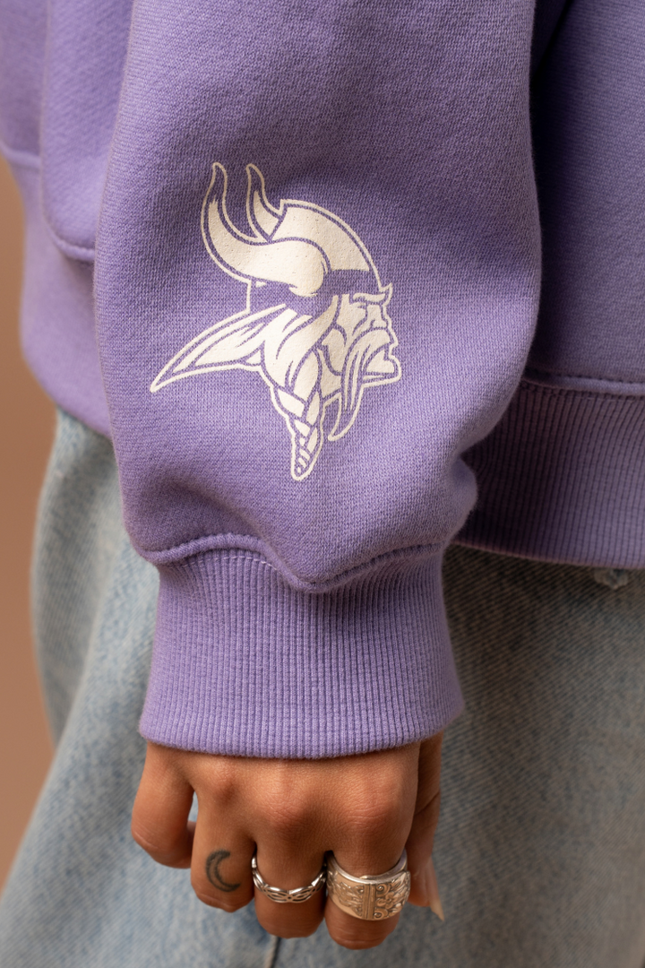 Purple crew neck sweatshirt sleeve with a white Vikings logo