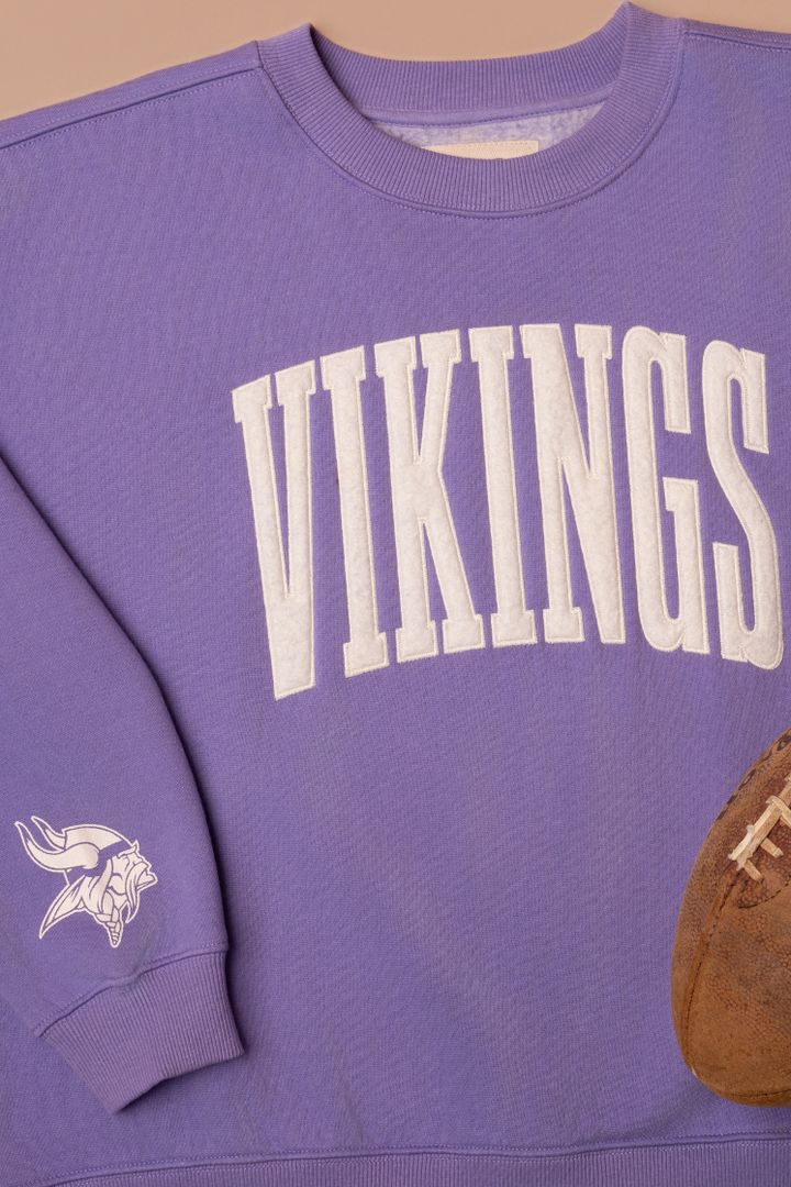 Purple crew neck sweatshirt with white 'Vikings' text and a white Vikings logo on the sleeve