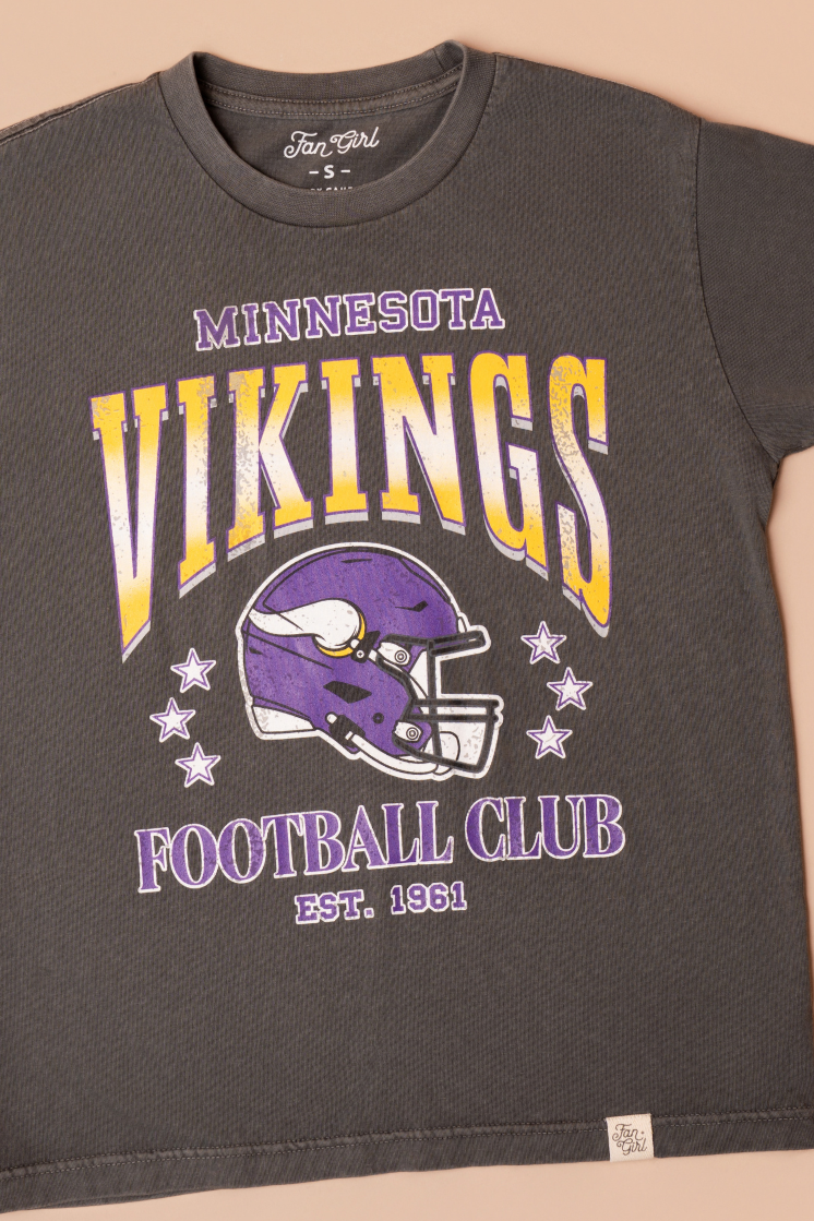 A faded black t-shirt with gold and purple 'Minnesota Vikings Football Club' and 'EST. 1961' text with a purple Vikings helmet graphic in the center