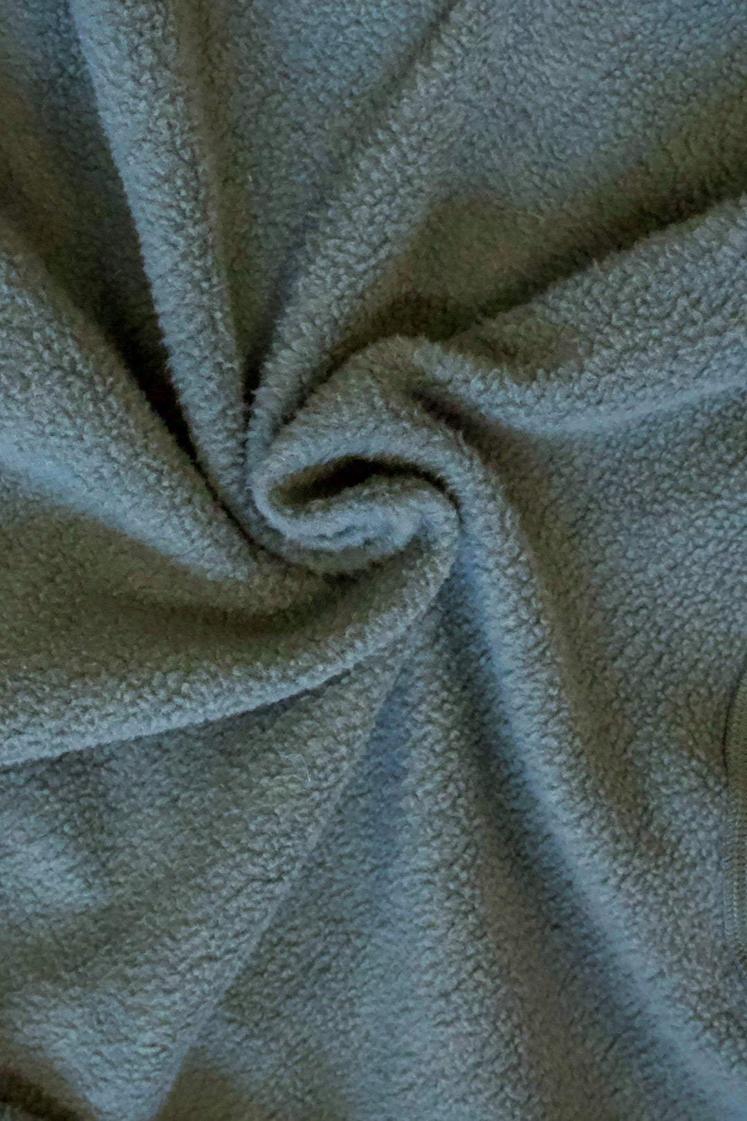 A close up photo of the green fleece lining of a sweatshirt.