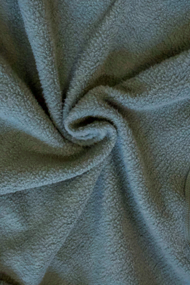 A close up photo of the green fleece lining of a sweatshirt.