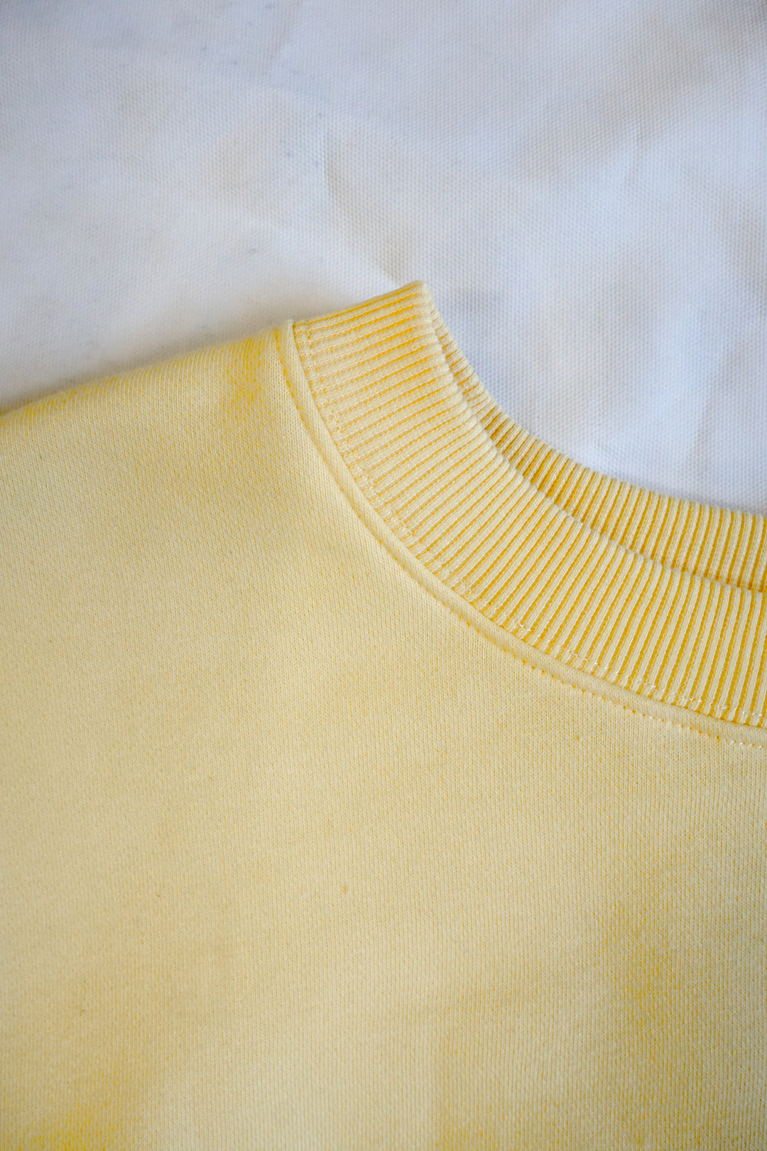 a close up image of a yellow crewneck collar that is thicker, mock-neck like