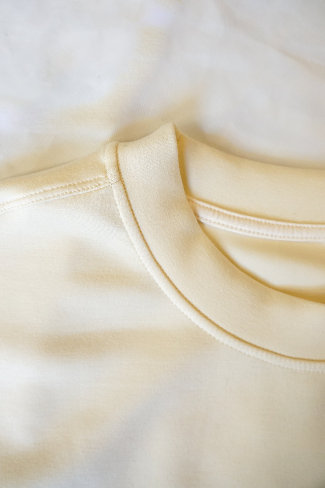 close up image of a bone colored collar of a supersoft crewneck
