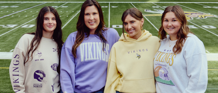 4 girls wearing Minnesota Vikings apparel at U.S. Bank Stadium