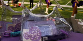 University of Minnesota Merch with sunglasses, a wallet, earrings, and perfume next to it 