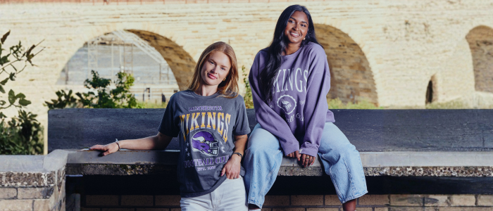 two girls on a bridge wearing a game day t-shirt