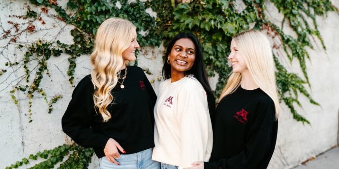 three girls smiling in university of minnesota fan apparel