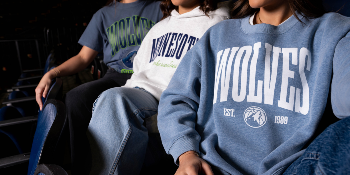 Three girls wearing Minnesota Timberwolves fan apparel , a hoodie, t-shirt, and crew neck at Target Center