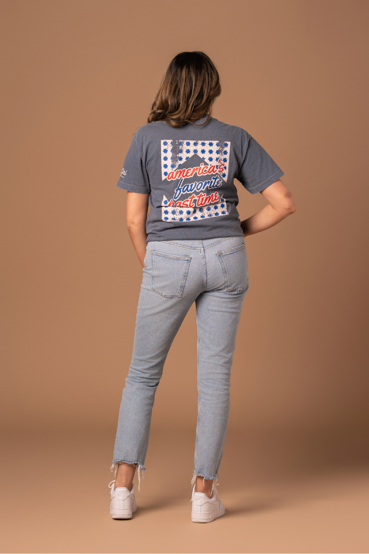 picture of the backside of a girl wearing a faded navy tee with red, cream, and blue vintage and worn-in inspired design 