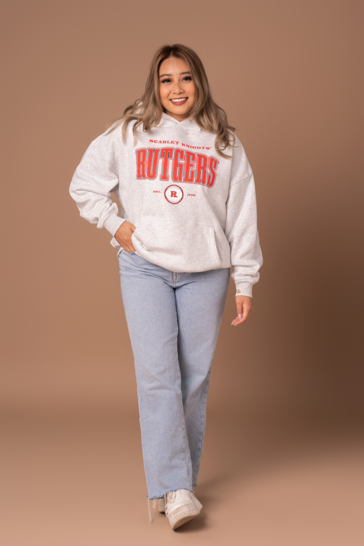 picture of a girl in a ash gray hoodie with a vintage inspired red, black, and white Rutgers University screenprinted design 