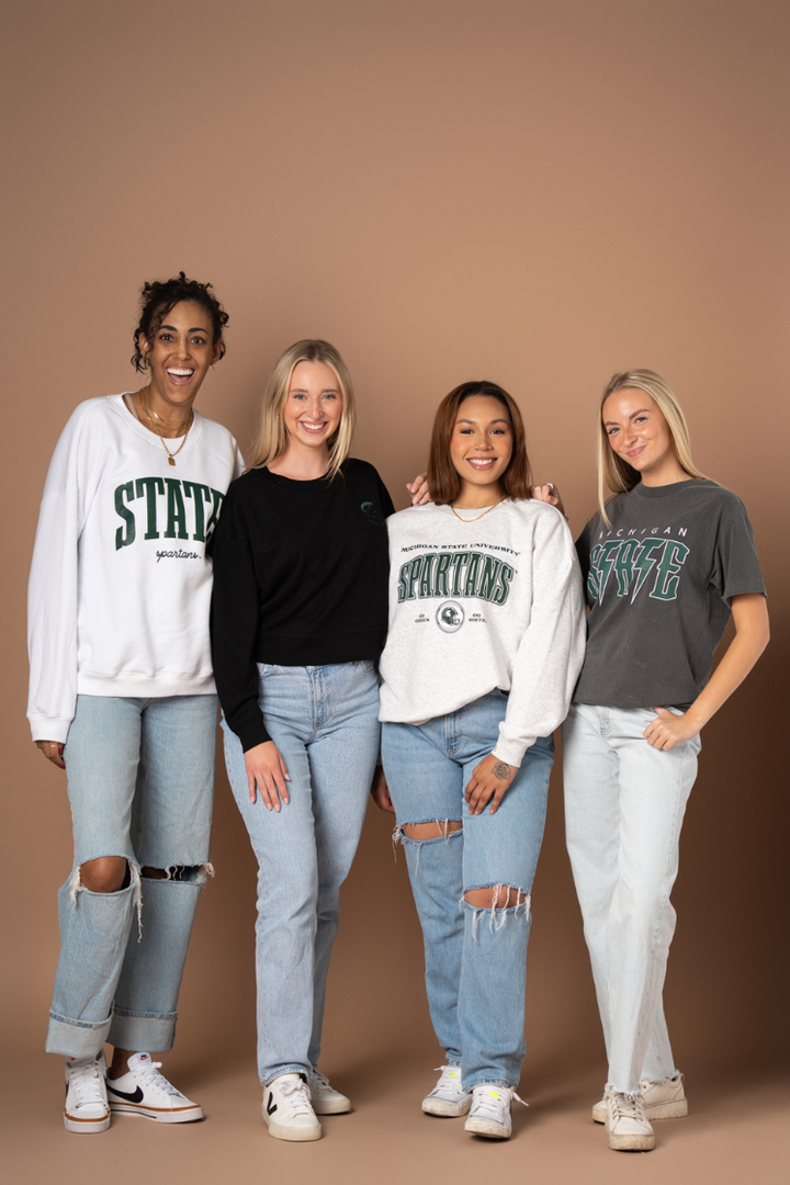 picture of four girls wearing Michigan State University apparel from Fan Girl clothing's campus collection