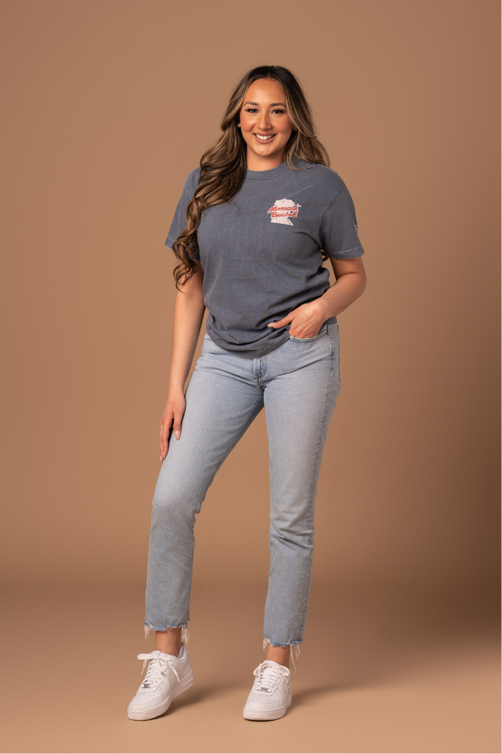 picture of a girl wearing a faded navy tee with red and cream vintage and worn-in inspired design that has a small design on the front right side for minnesota baseball