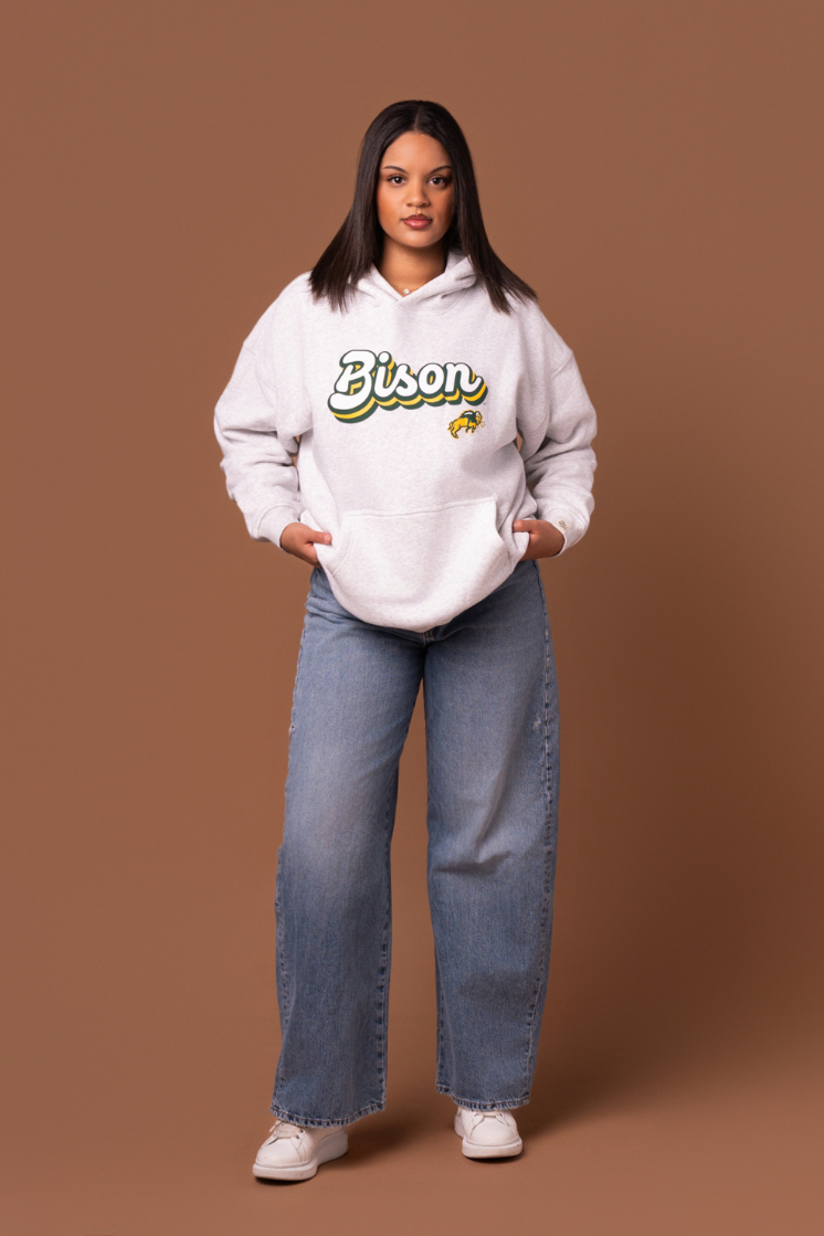 Women wearing a heather grey hoodie with 'Bison' text and a Bison logo under it 