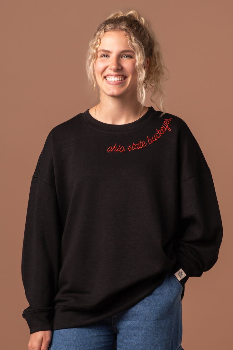 close up of a girl wearing a black Buckeyes Supersoft Crew Neck with red embroidery detail 