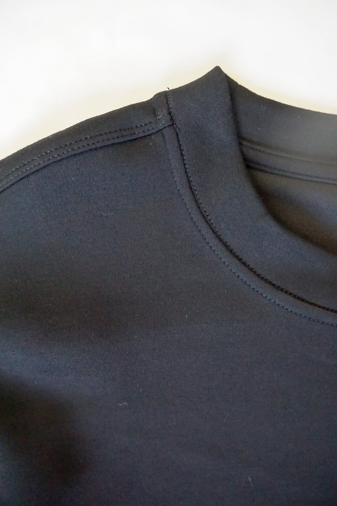 close up picture of the collar of a supersoft crew neck in black