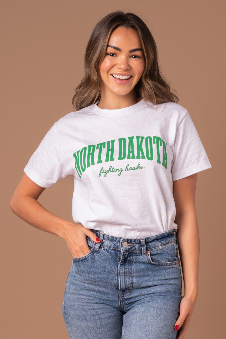 a close up image of a girl wearing a white tee with Kelly green writing that says North Dakota in bold text with Fighting Hawks in cursive below it