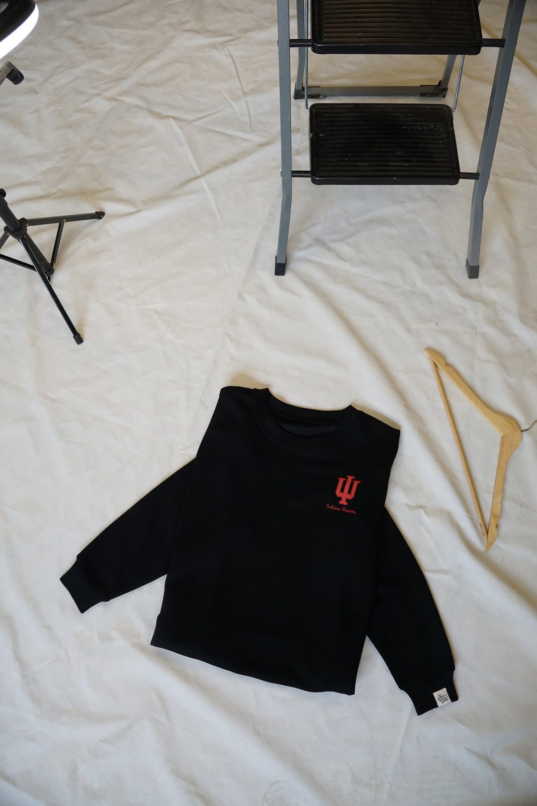 a zoomed out picture of a Hoosiers Supersoft Crew Neck on the ground, black, super soft athlesiure material with a crimson embroidered University of Indiana logo