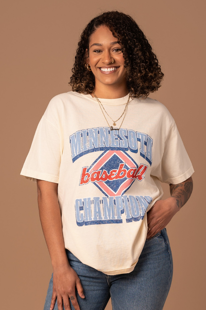 picture of a girl wearing cream colored cotton t-shirt with a red white and blue vintage inspired minnesota baseball screenprinted design 