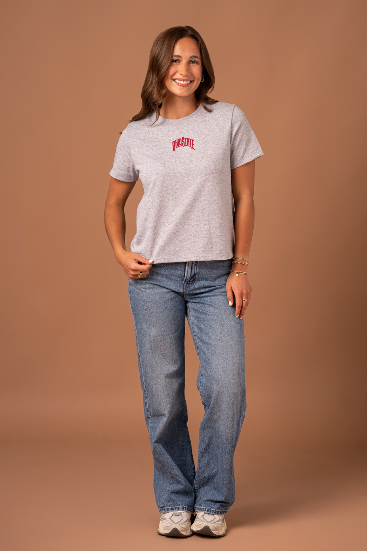 Woman wearing a gray t-shirt with a small, red Ohio State graphic