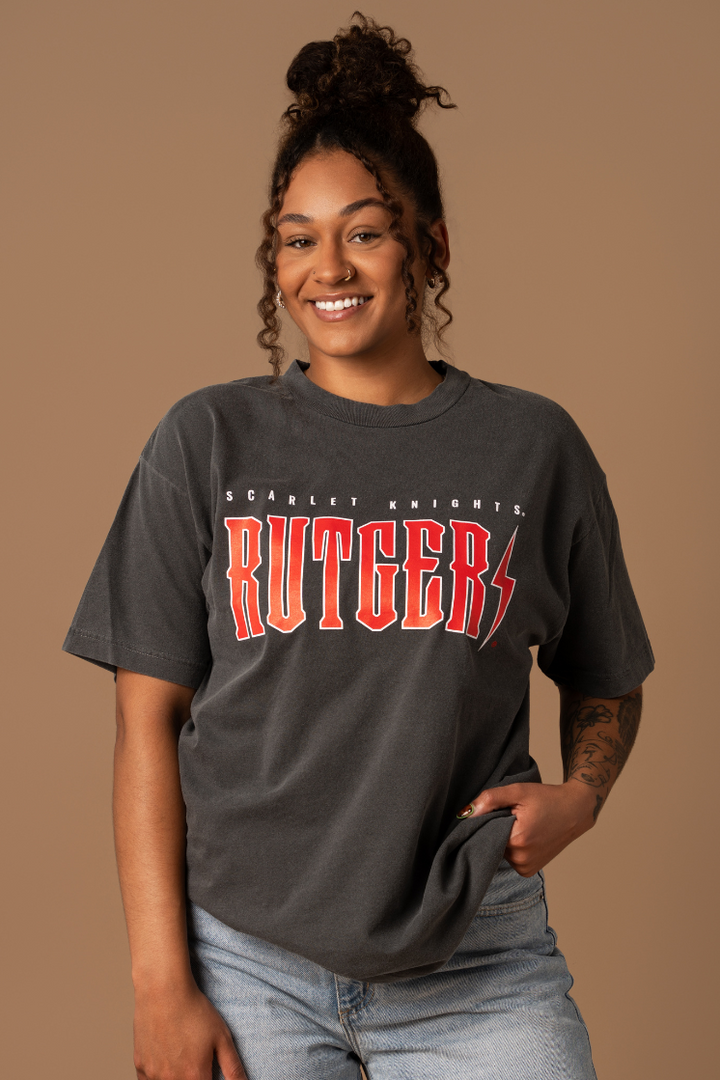 close up picture of a girl wearing a faded black cotton Rutgers University Vintage Band T-shirt in red and white detail
