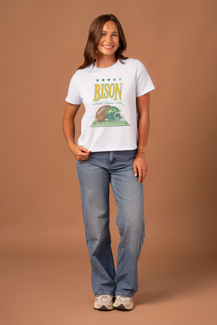 a girl wearing a white boxy tee with "Bison" written on it with a field and football graphic