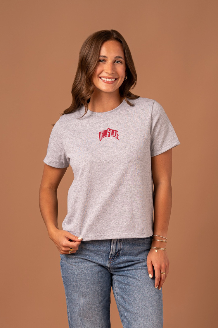 Woman wearing a gray boxy t-shirt with a small, red Ohio State graphic in the center