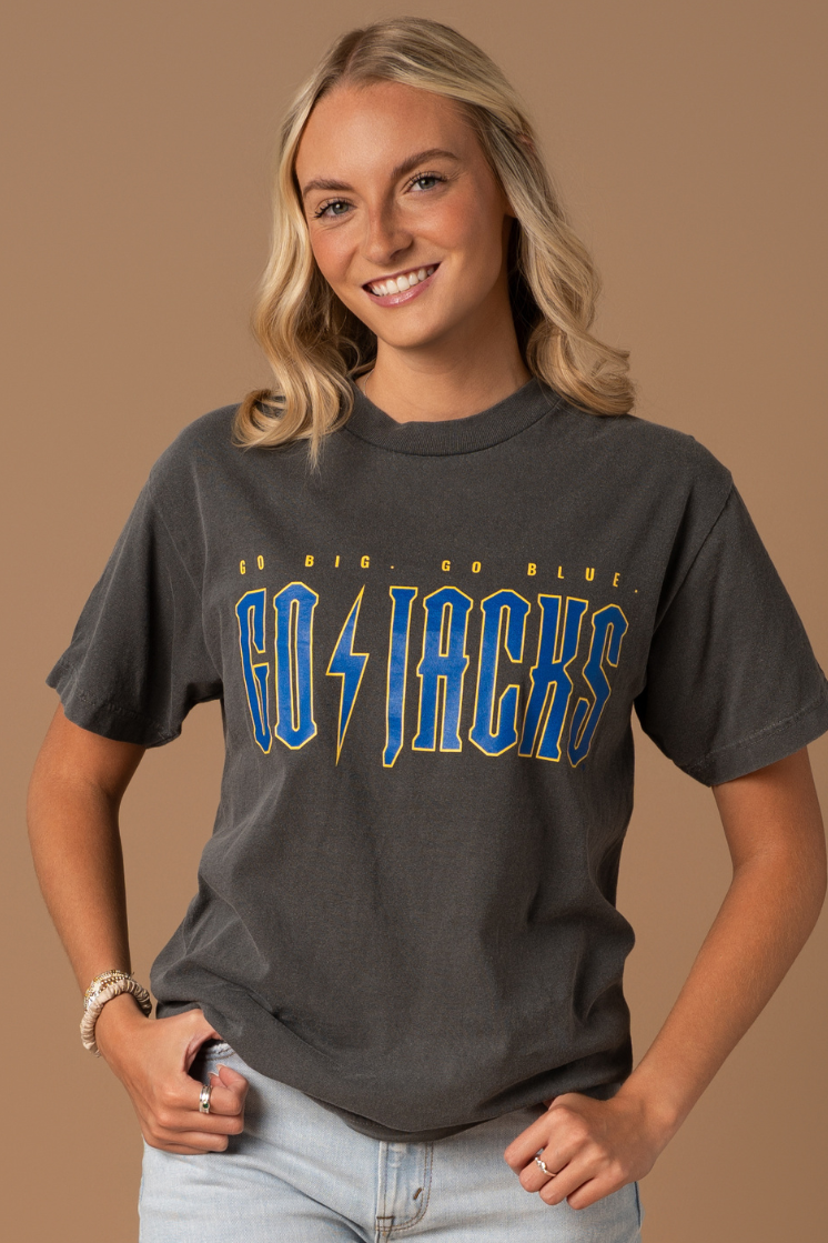 close up image of a girl wearing a faded black tee with Go Jacks screenprinted in blue and yellow with lighting bolt design