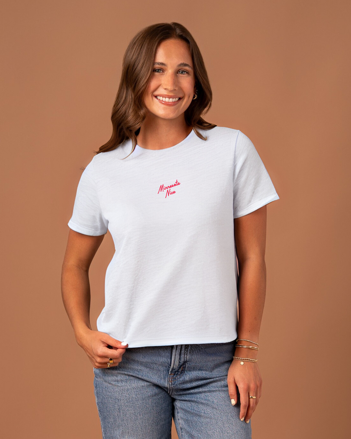 Woman wearing a white t-shirt with red embroidered 'minnesota nice' text