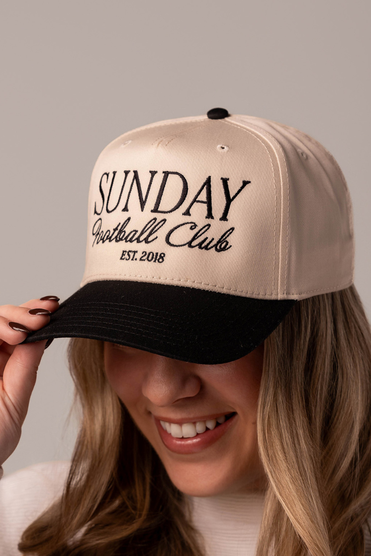 Close up of a girl wearing a trendy game day hat that has embroidered design on it that say s "Sunday Football Club"which would be perfect for women football fans who want understated fashion,.