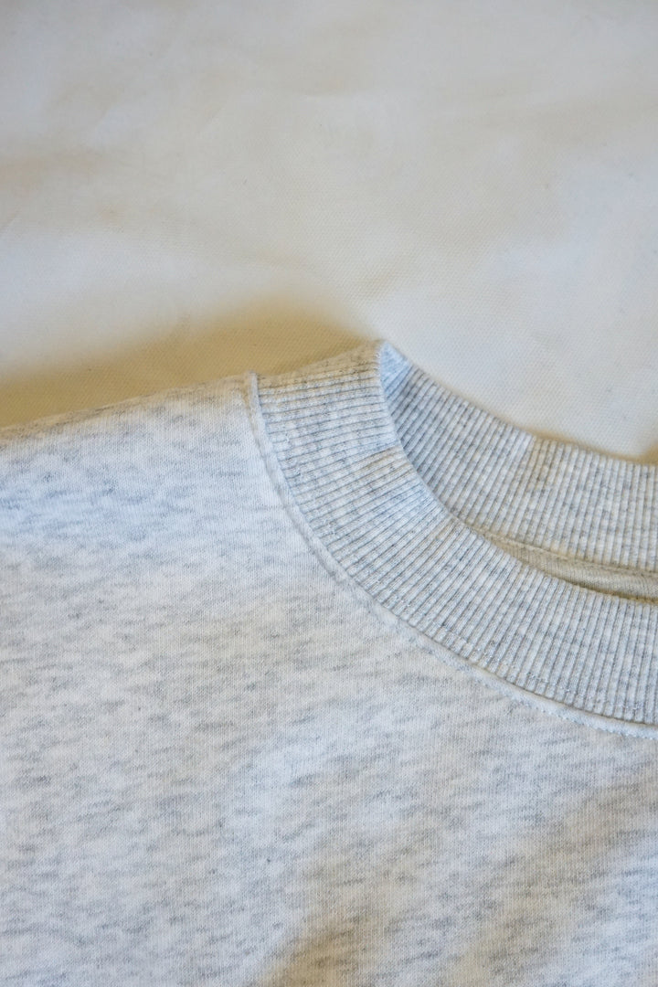 a close of a collar of a gray crewneck with a thick, mock-neck like