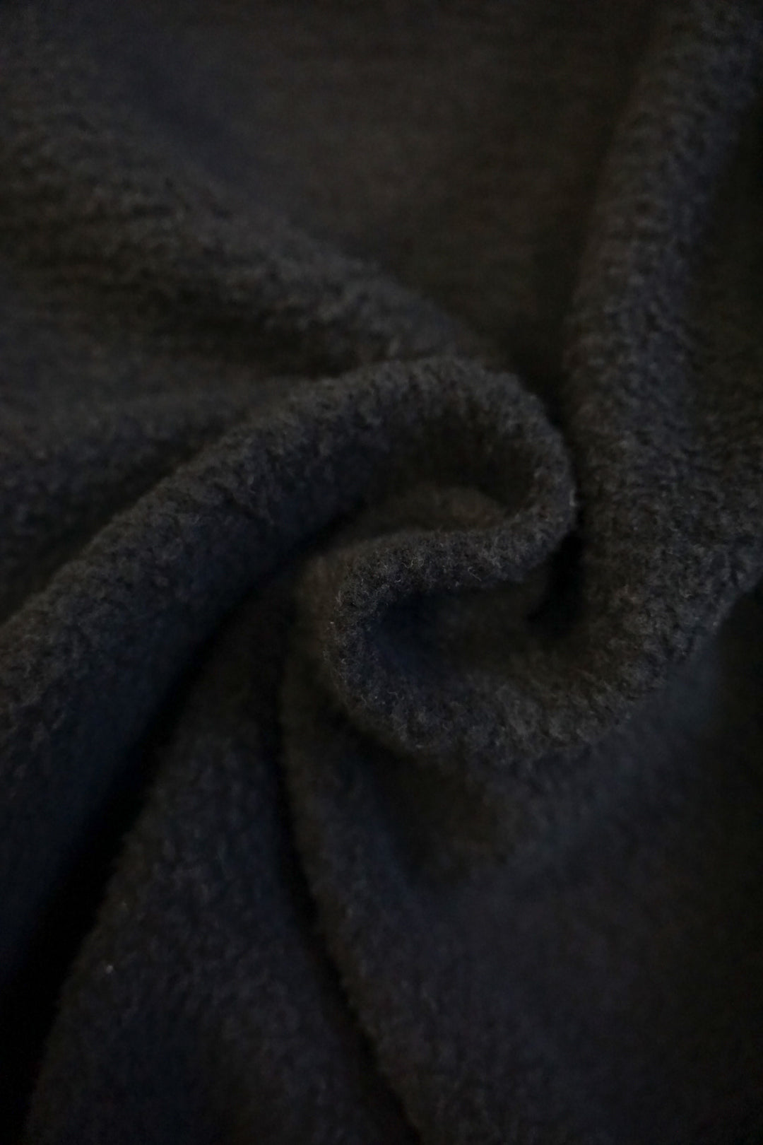 close up of the interior fleece lining of a black crew neck sweatshirt 