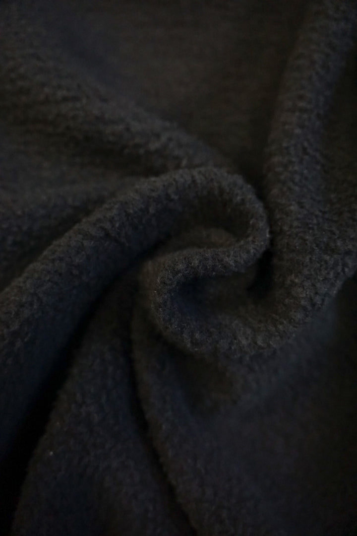 close up of the interior fleece lining of a black crew neck sweatshirt 