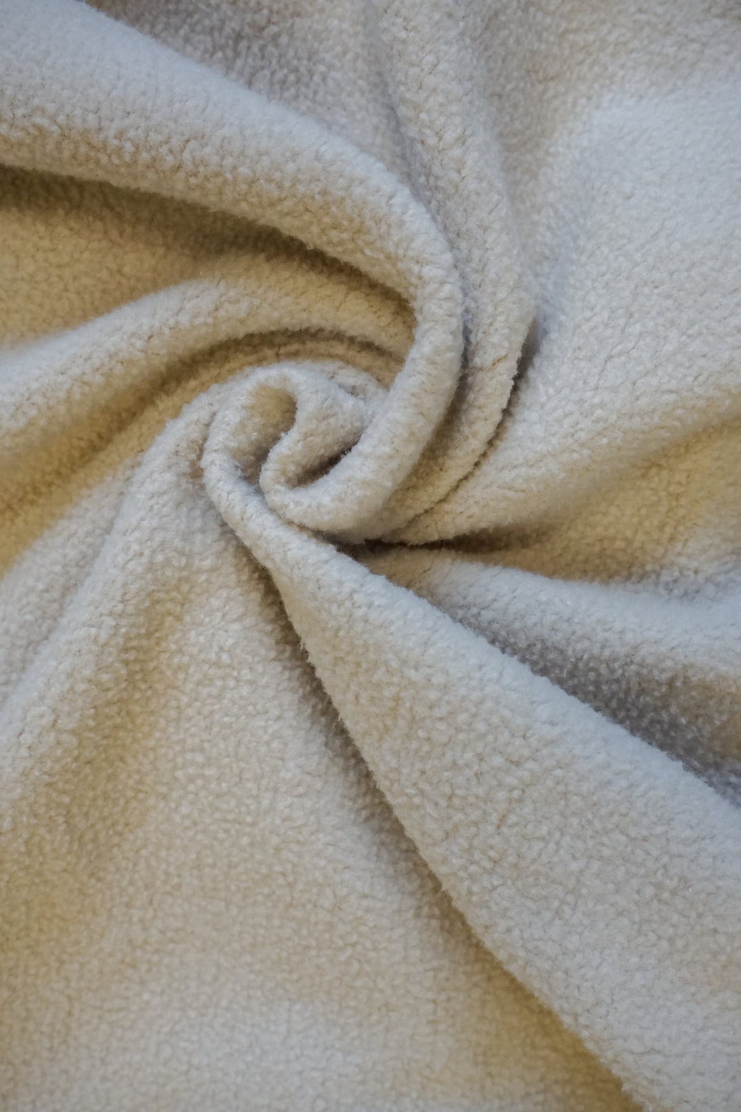 a close up twist image of the inside fleece lining of a tan crewneck