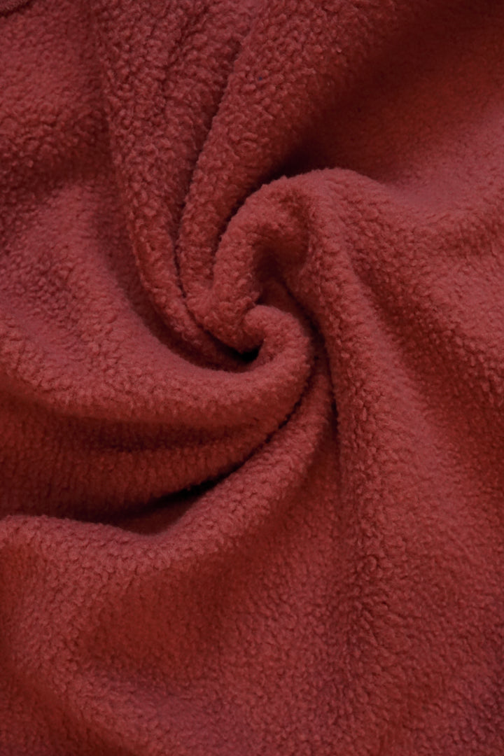 close up image of the inside of a maroon crewneck with fleece lining