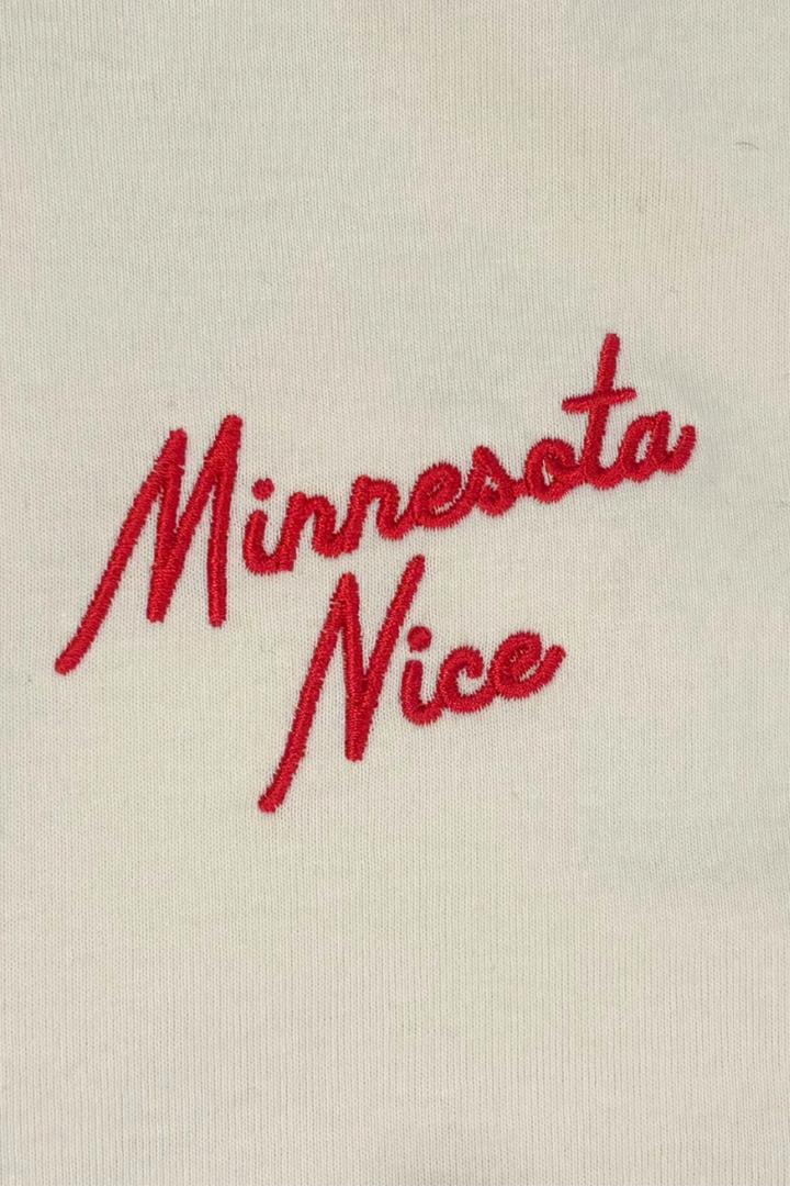 Red embroidered text 'Minnesota Nice' on a white t-shirt