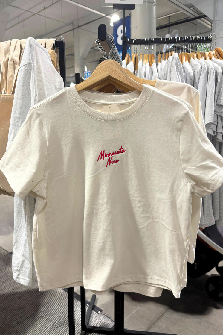 White t-shirt with red embroidered 'minnesota nice' text on a hanger