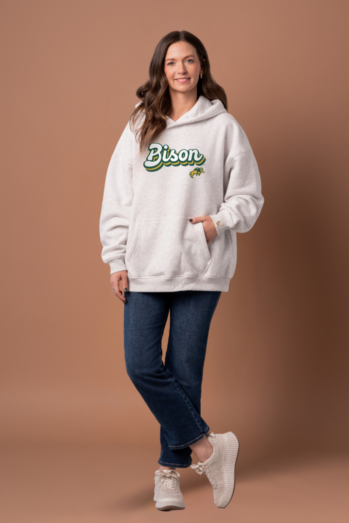 Women wearing a heather grey hoodie with 'Bison' text and a Bison logo under it 