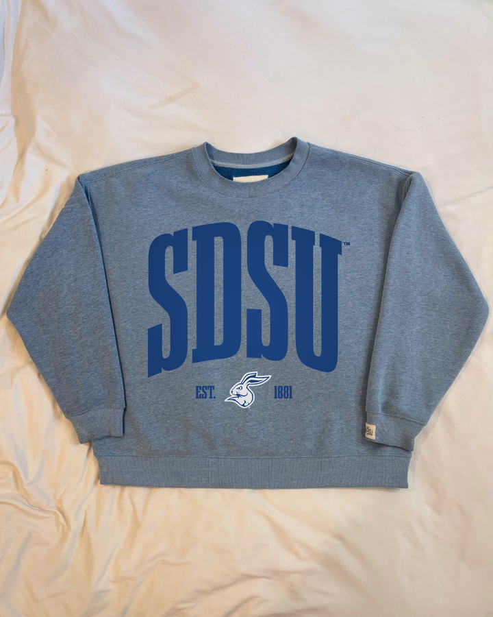 Blue crew neck sweatshirt with darker blue 'SDSU' text and a Jackrabbit logo under it in white