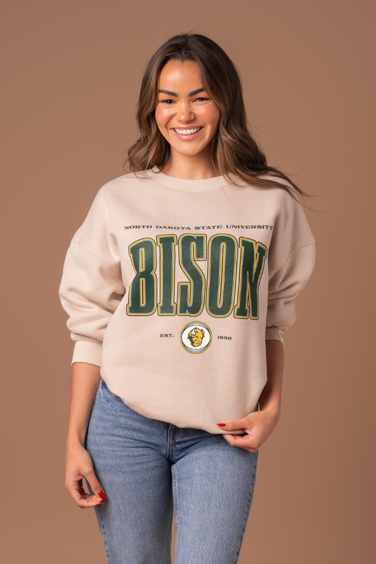 Woman wearing a NDSU Bison crew with fleece lining and green and gold decoration